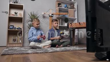 漂亮的、严肃的十几岁的兄弟坐在地毯上，用游戏游戏游戏竞争